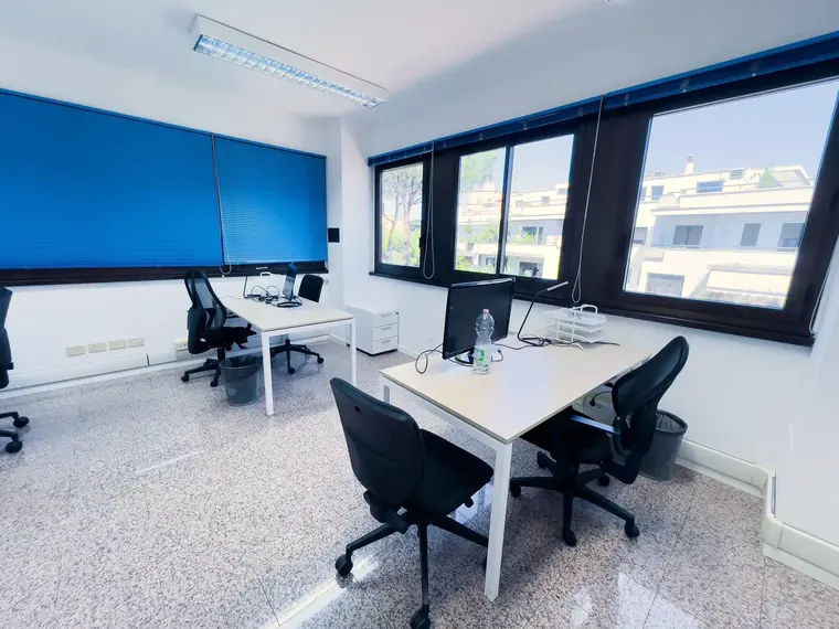 Ufficio condiviso con quattro postazioni e tapparelle blu