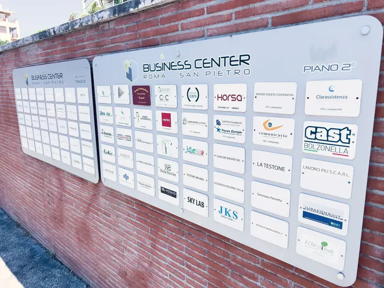 Parete con le targhe delle aziende domiciliate nel business center